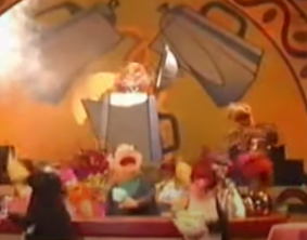 Various Muppets with coffee cups dance against a backdrop with giant coffee pots